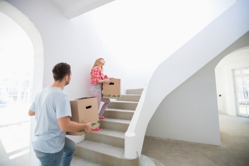 Movers carrying items through a Brixton flat with stairs