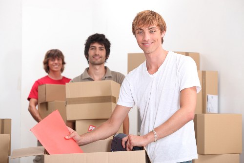 Team member wearing PPE while handling moving equipment and household items